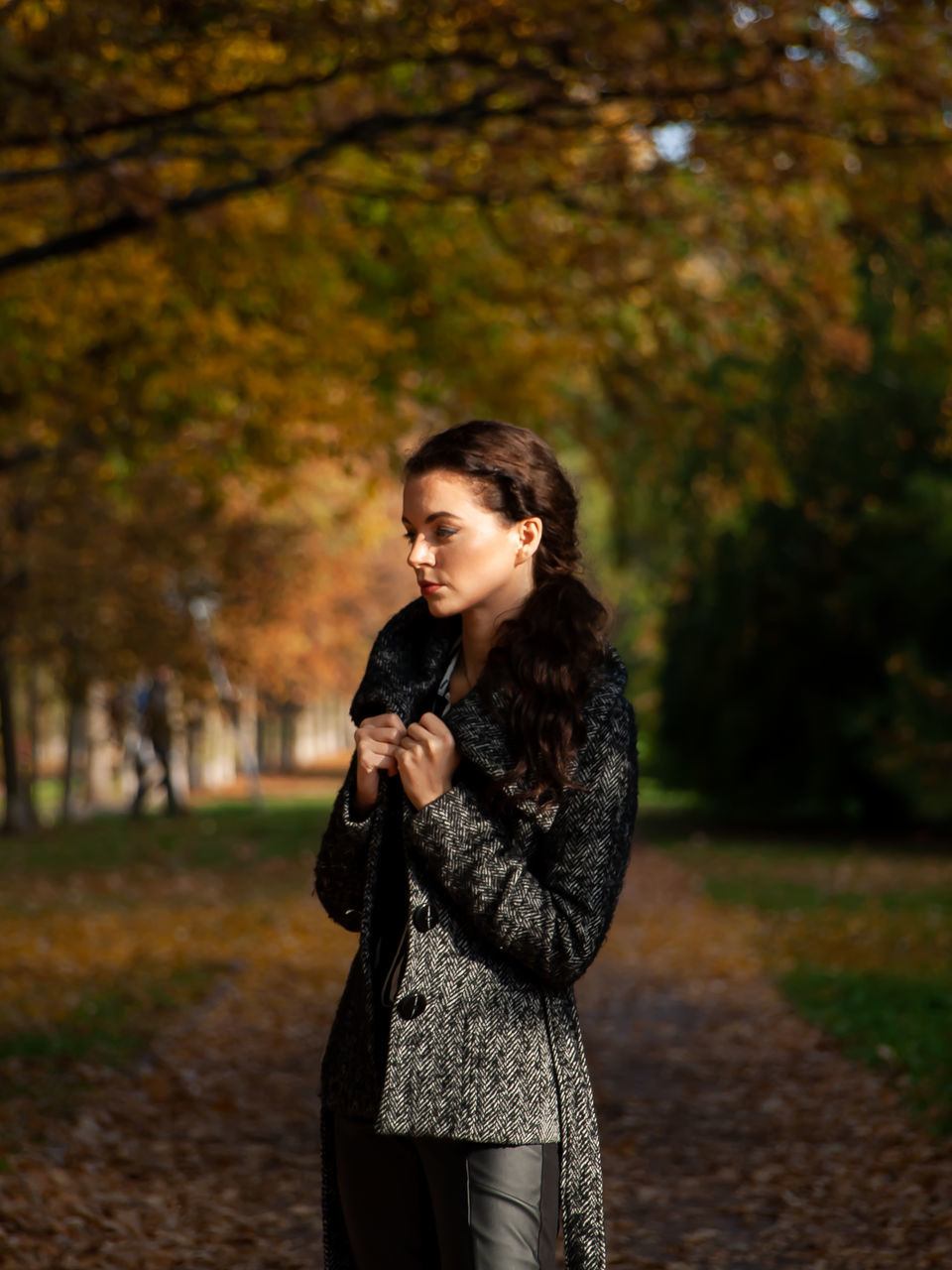 one person, autumn, young adult, tree, three quarter length, young women, focus on foreground, standing, real people, lifestyles, clothing, leisure activity, change, nature, front view, looking, plant, day, hairstyle, hair, contemplation, outdoors, teenager, beautiful woman, warm clothing
