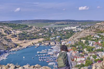 Top view of the balaklava bay, crimean peninsula.  male tourist with backpack takes photos 