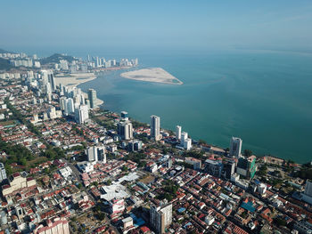 High angle view of buildings by sea against sky