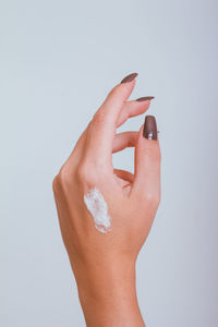 Cropped hand of woman gesturing against white background