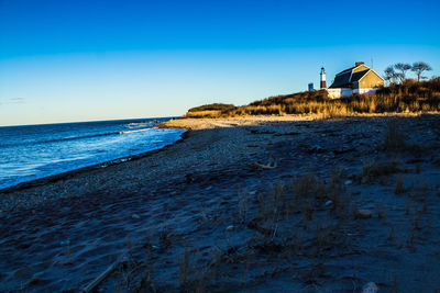 Scenic view of beach against clear blue sky