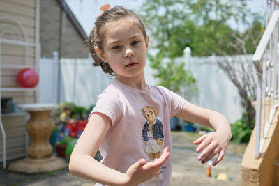 Cute young girl playing in the backyard on a sunny day