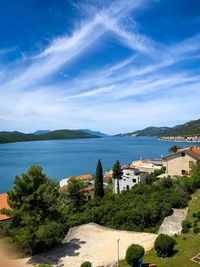 High angle view of buildings by sea against blue sky