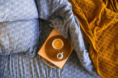 High angle view of coffee cup on bed