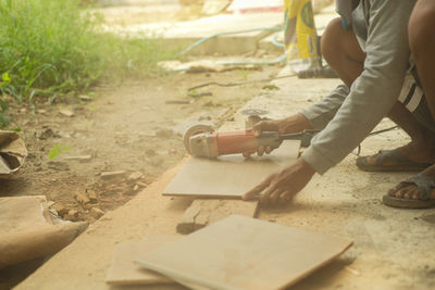 Workman cutting the floor tile by the electrical cutting machine at the construction site