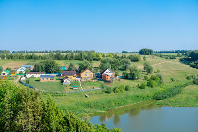 Scenic view of landscape and houses against clear sky