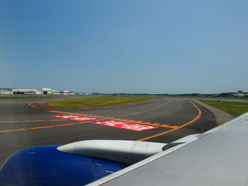 Airplane on runway against clear blue sky