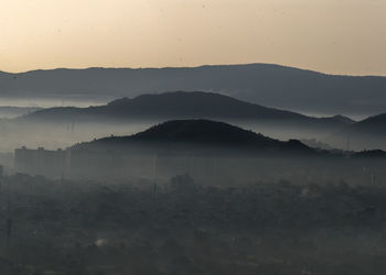 Scenic view of silhouette mountains against sky during sunset