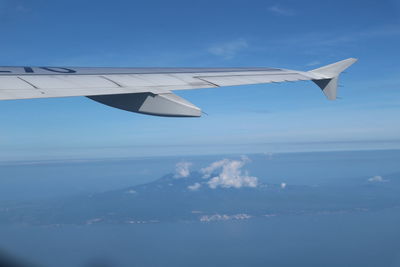 Airplane flying over sea against sky