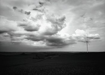 Scenic view of field against cloudy sky