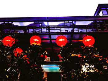 Low angle view of illuminated lanterns against sky at night