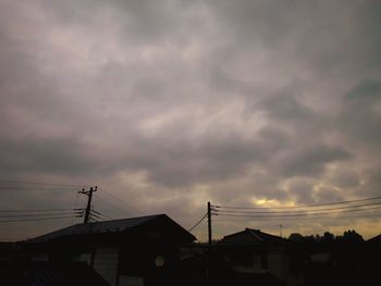 Silhouette houses against sky at dusk