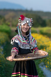 Woman holding a smiling while standing against blurred background