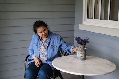 Young woman sitting on table at sidewalk cafe