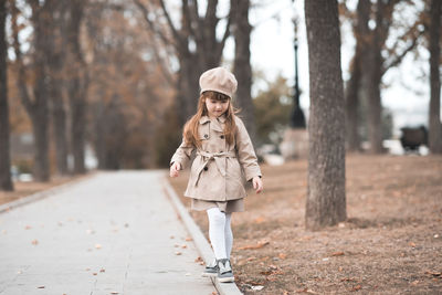 Full length of girl walking on footpath at park