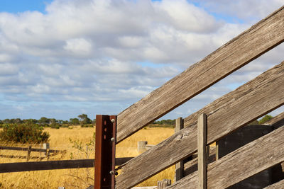 Low angle view of wooden cattle ramp fence against sky