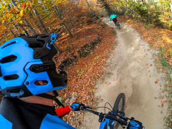 Man riding bicycle on autumn leaves