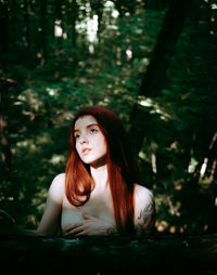 Portrait of young woman sitting in forest