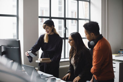 Female and male colleagues analyzing product in creative office