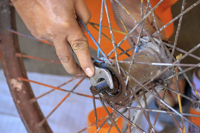 Close-up of man working on metal chain