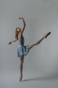 Ballet dancing against gray background