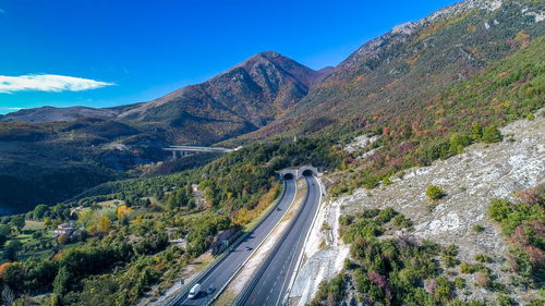High angle view of road amidst mountains against blue sky