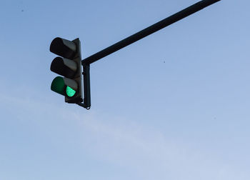 Low angle view of road signal against blue sky