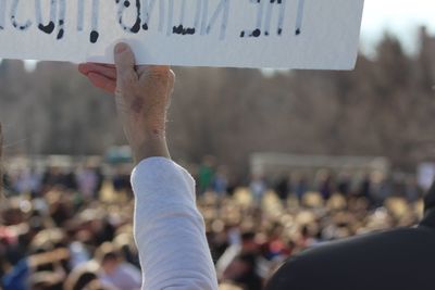 Cropped hand holding banner with text during protest