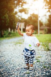 Full length of boy photographing with mobile phone