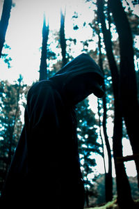 Side view of person standing on cross in forest