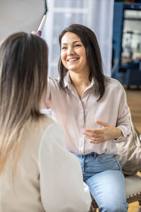 Portrait of smiling friends using mobile phone