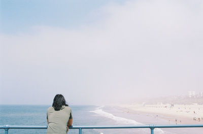 Rear view of woman looking at sea against sky