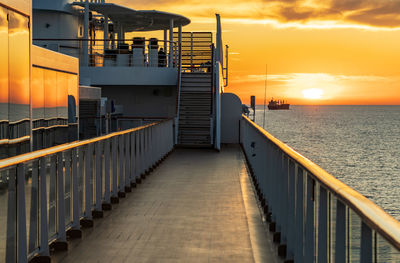 Bridge over sea against sky during sunset