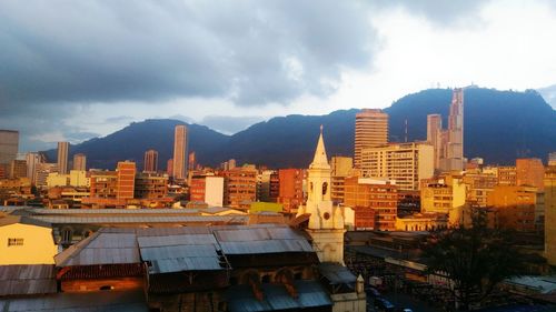 View of cityscape against cloudy sky