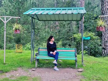 Full length of woman sitting on bench