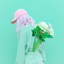 Rear view of woman holding umbrella against white background