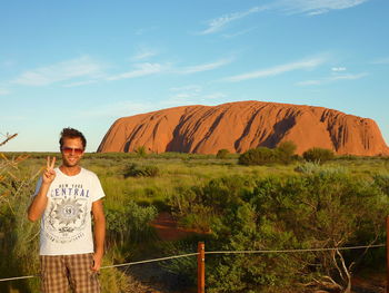 Portrait of smiling man standing on land against sky