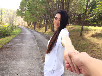 Cropped image of man holding hand of mature woman on road