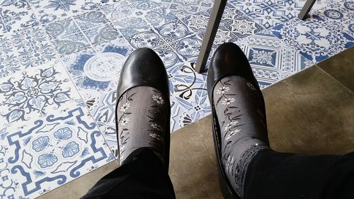 Low section of woman standing on tiled floor