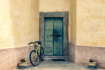 Bicycle leaning on wall of building