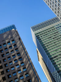 Low angle view of modern buildings against clear blue sky