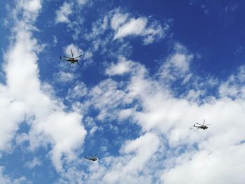 Low angle view of helicopters flying in sky