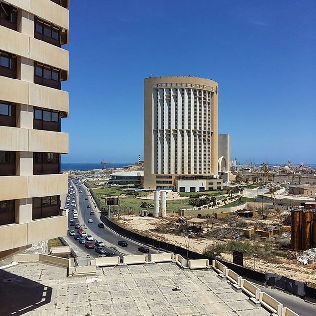 architecture, built structure, building exterior, blue, clear sky, city, sunlight, building, copy space, day, shadow, residential structure, sky, history, outdoors, residential building, window, travel destinations, sunny, cityscape