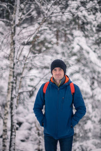 Portrait of young man standing on snow