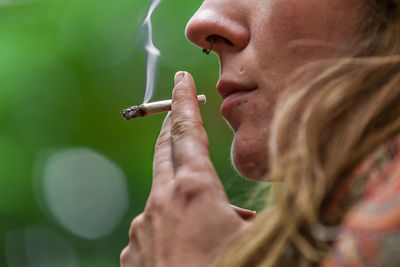 Close-up of woman smoking weed outdoors