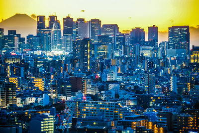 High angle view of illuminated city buildings against sky