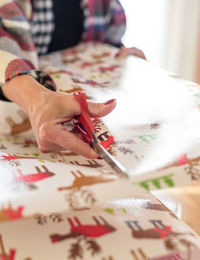 Close-up of hand holding paper on table