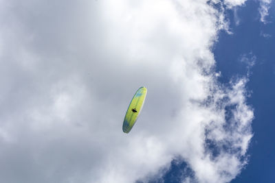 Low angle view of person paragliding against sky