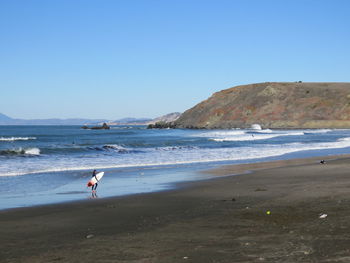 Side view of a surfer on beach