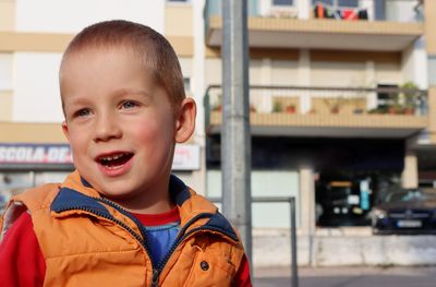 Portrait of cute boy standing in city